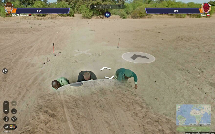 Three men are humorously captured half-buried in sand, creating a funny Google Street View moment.