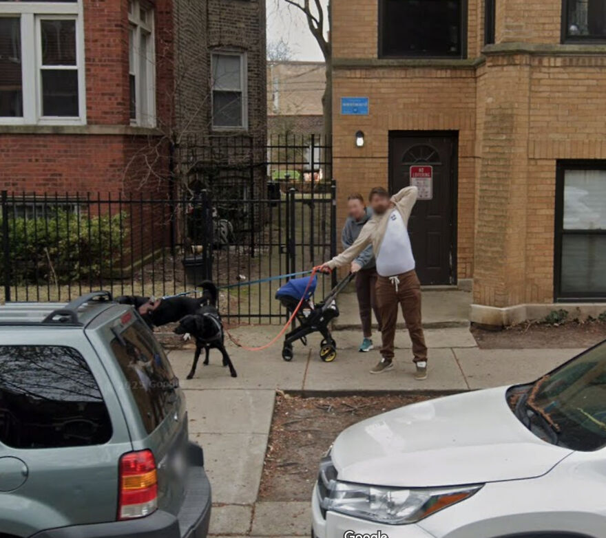 A funny Google Street View photo of two men on a sidewalk, one appearing to stretch while holding a leash.