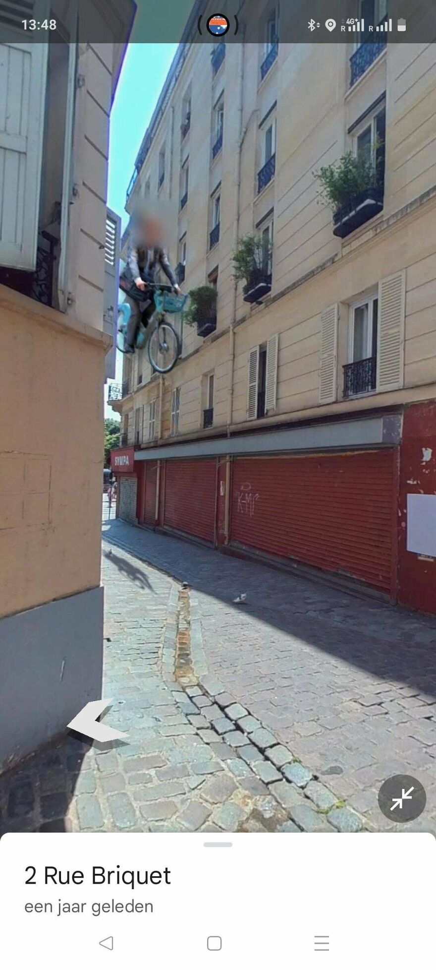 A bizarre Google Street View photo showing a person seemingly floating on a bike down a street between buildings.