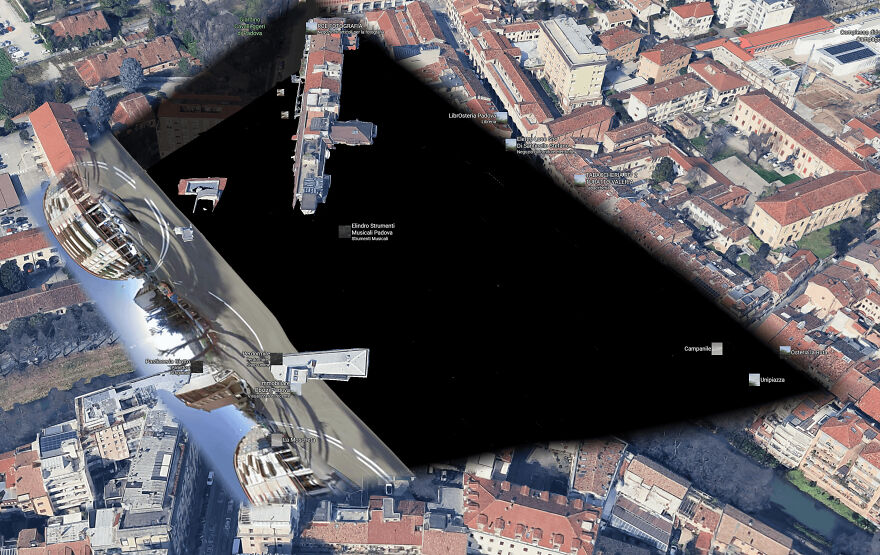 A funny Google Street View image featuring a large, dark, distorted area obscuring part of a city.