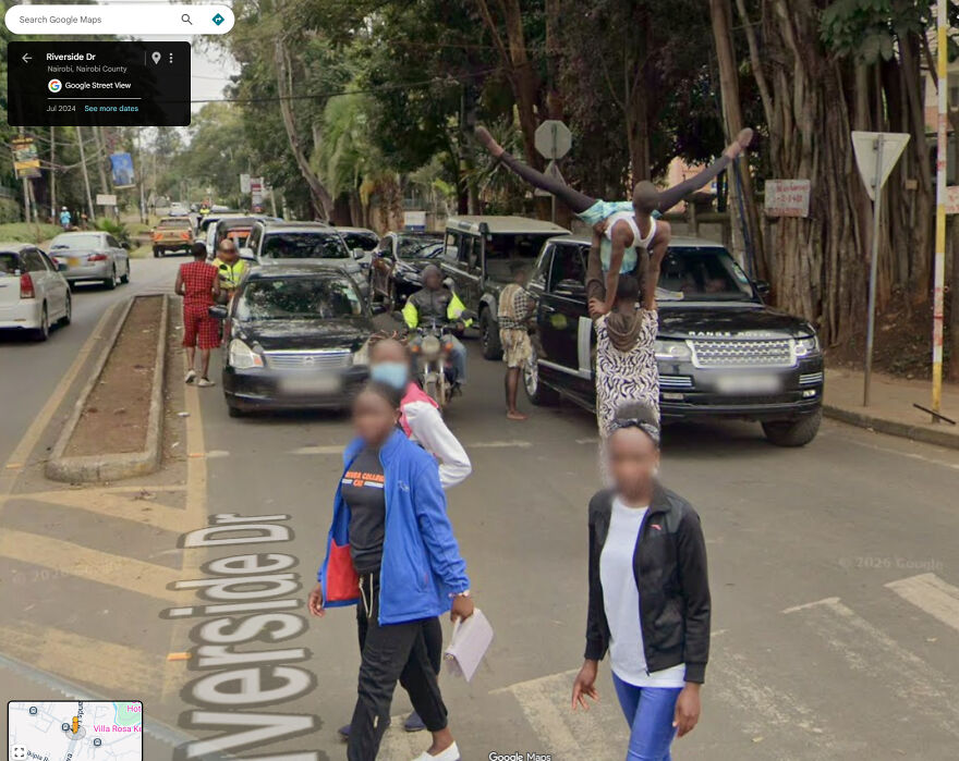 A bizarre Google Street View capture of people performing acrobatic stunts on a vehicle in traffic.