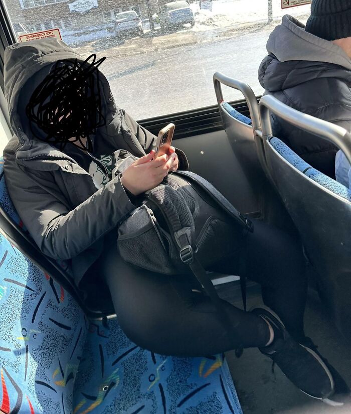 A person with their face obscured, lounging with their feet on a seat on public transport, showing a lack of basic human decency.