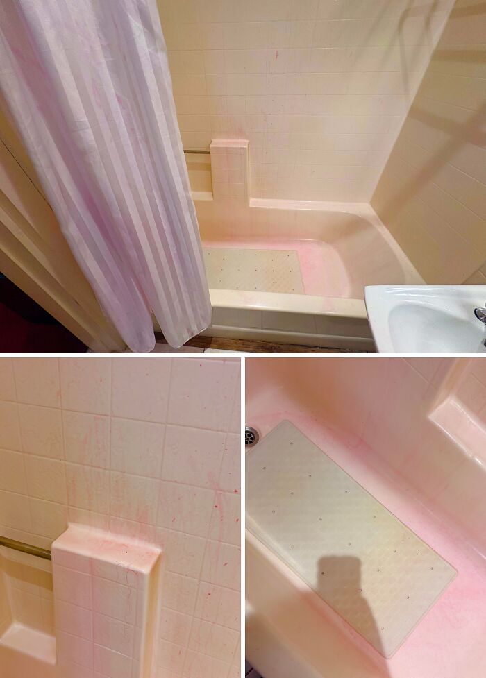 A dirty bathroom with pink stains on the bathtub and tiles, lacking basic human decency in cleanliness.