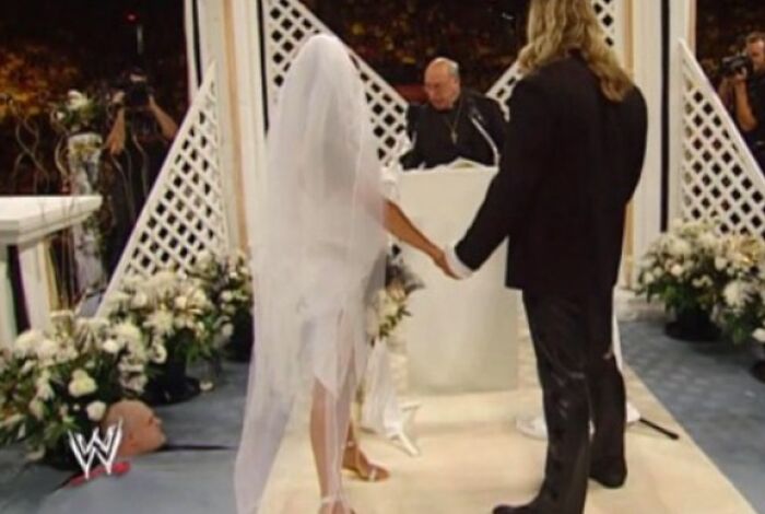 A picture of a wedding ceremony with a bald man lying on the ground, creating a 'When You See It' moment.