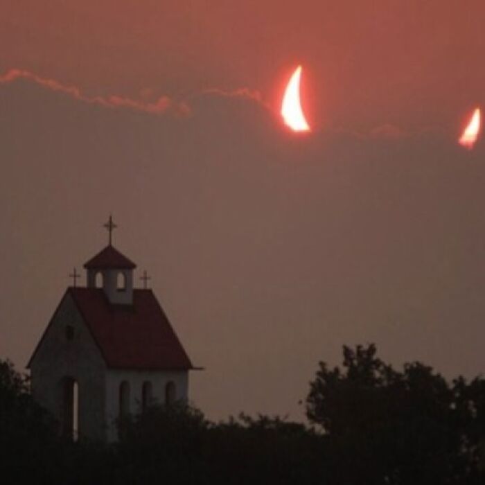 A small church under a sky with crescent-shaped clouds, creating a unique when you see it image.