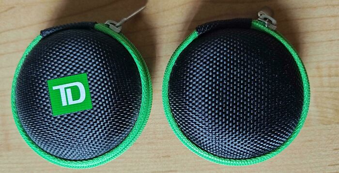 Two small, round, black and green zippered cases, exemplifying insulting consumerism and price difference.
