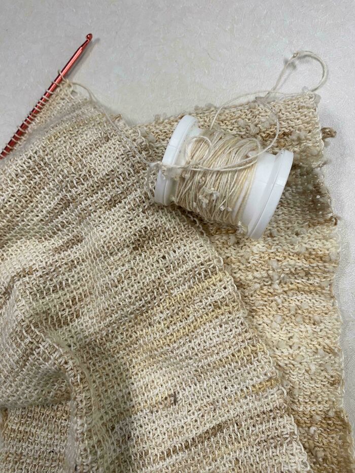 Knitting project with cream yarn showing recycled knitting techniques