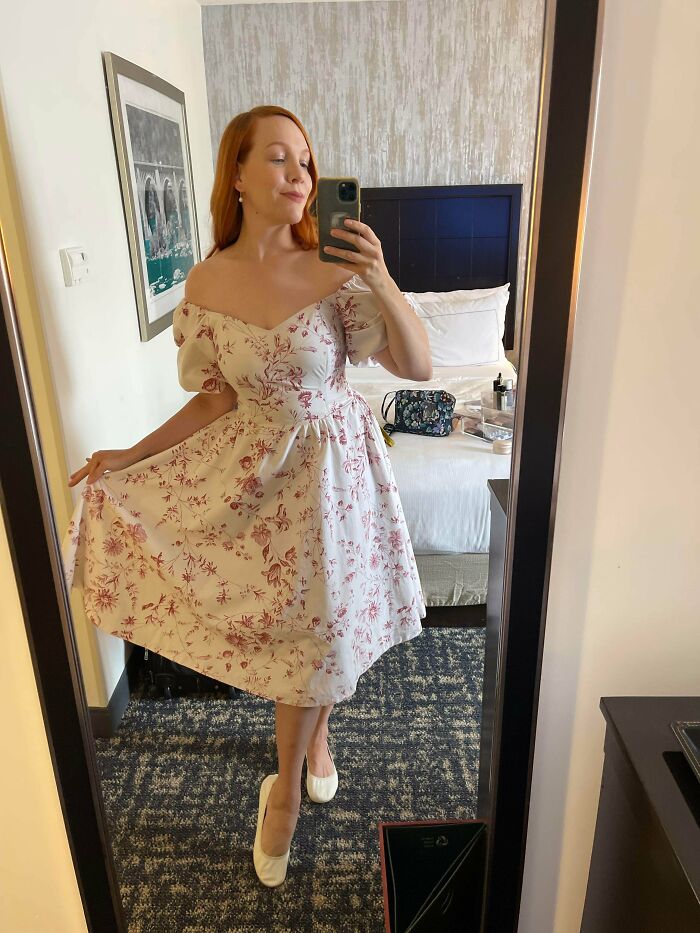 A woman in a floral dress, celebrating unexpected things people made out of things that would’ve been thrown away.