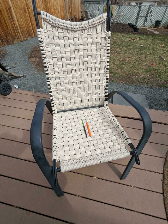 An outdoor chair, newly re-woven with things that would've been thrown away, sits on a wooden deck.