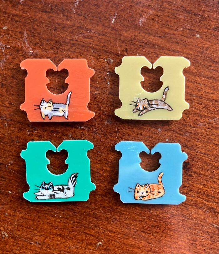 Four colorful bread tags, transformed into mini artworks with cute cat illustrations on each, showing things made from thrown away items.