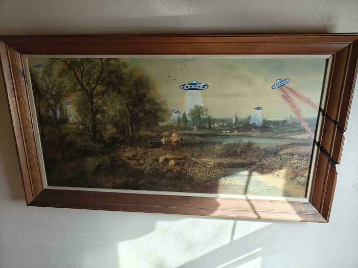 An old painting depicting a landscape with people and trees, creatively modified with alien UFOs drawn over it.