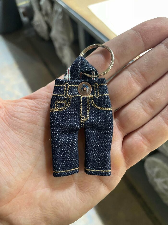 A miniature denim jeans keychain held in a hand, an unexpected item made from things that would've been thrown away.