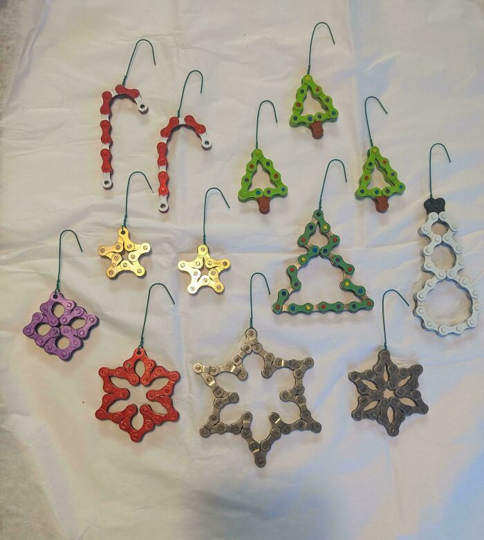 Various Christmas ornaments including candy canes, trees, stars, and snowflakes made from bicycle chains, things that would have been thrown away.