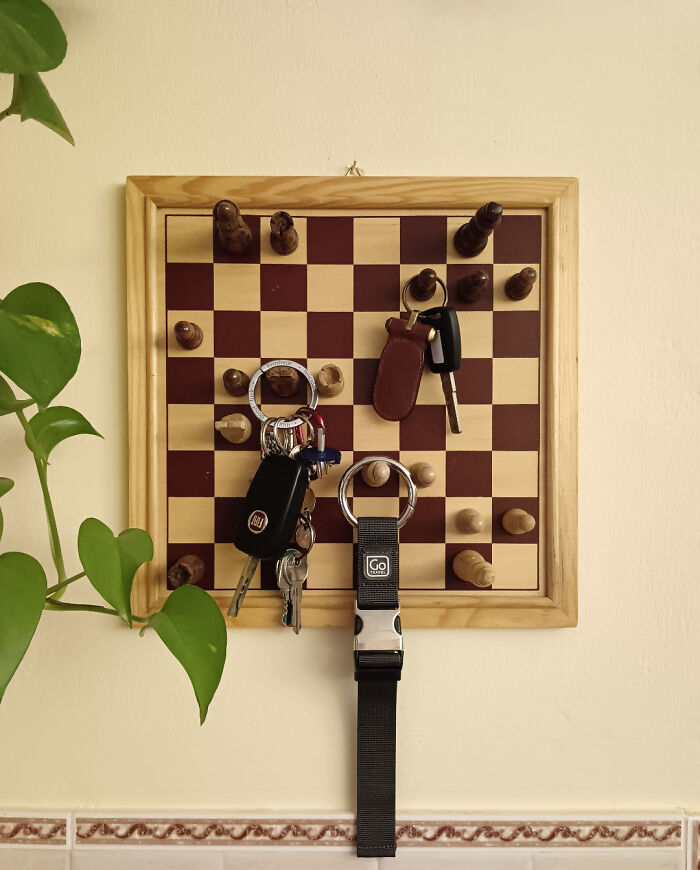 A chess board is used as a key holder, repurposed from things that would've been thrown away.