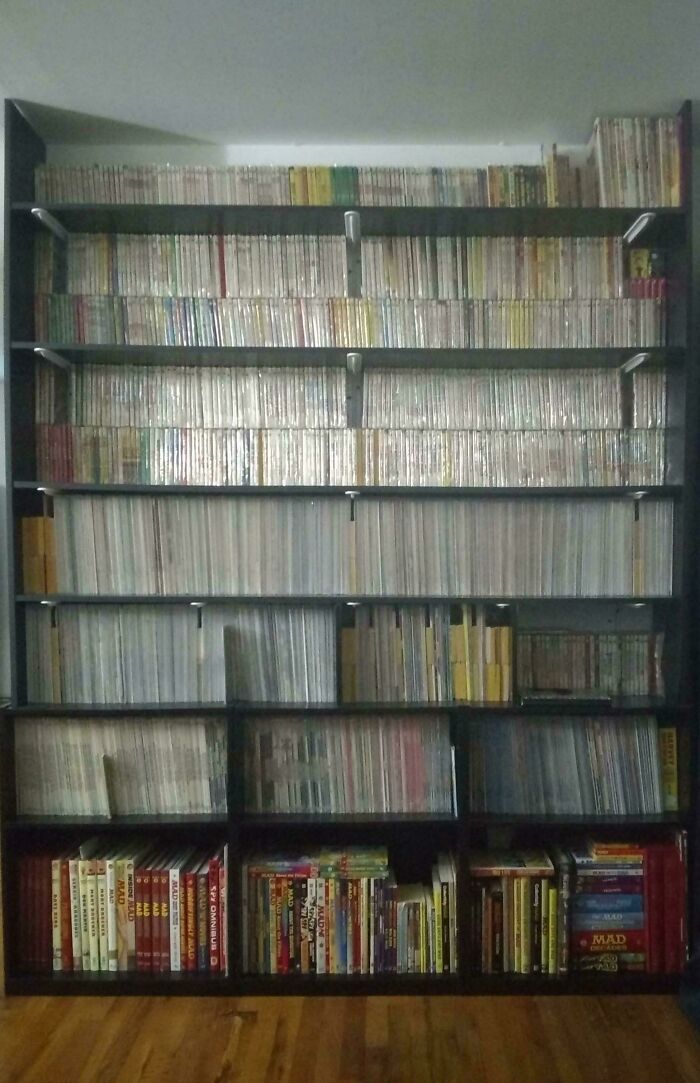 A floor-to-ceiling bookshelf filled with a fascinating collection of books and magazines, showcasing an unexpected variety.