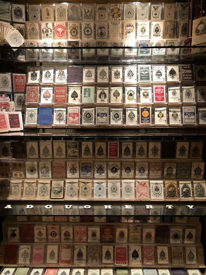 A fascinating collection of playing cards from various decks, meticulously displayed in glass cases.