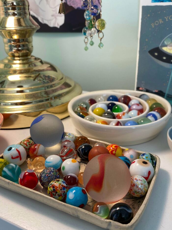 A fascinating collection of colorful glass marbles displayed in bowls and on a tray, highlighting unexpected beauty.