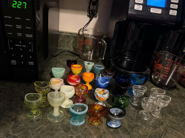 A fascinating collection of colorful glass egg cups on a kitchen counter, showcasing unique and unexpected items.