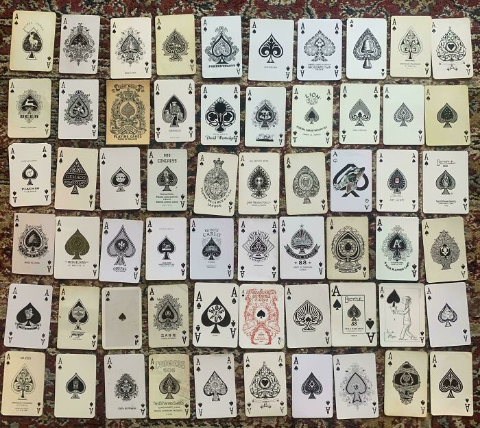 An unexpected and fascinating collection of various ace playing cards laid out on a rug.