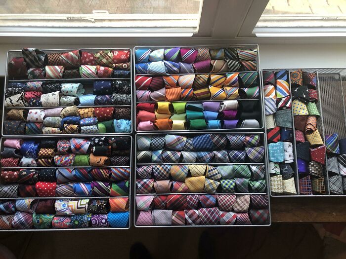 A massive collection of neatly folded colorful ties arranged in trays, a fascinating collection of mens accessories.