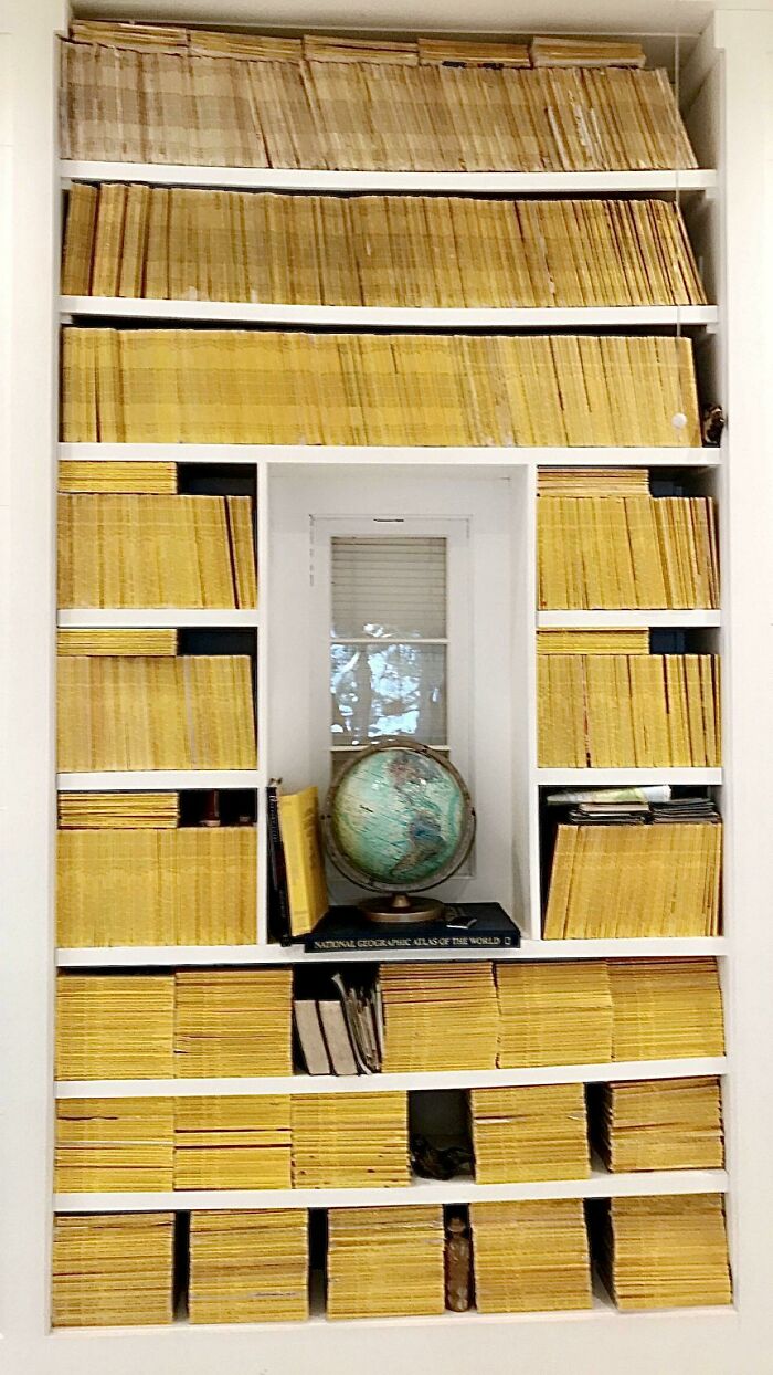 A fascinating collection of vintage National Geographic magazines filling shelves around a globe, showcasing years of publications.