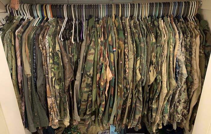 A fascinating collection of camouflage clothing hanging neatly in a closet, showcasing various patterns and hues.