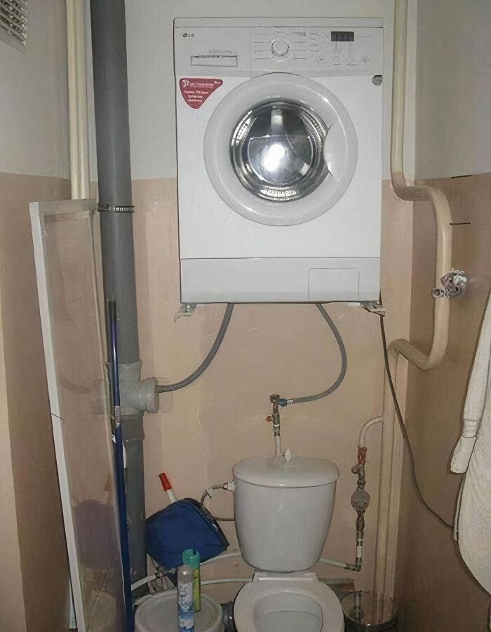 A washing machine installed precariously above a toilet, a clear example of architecture and design fails.