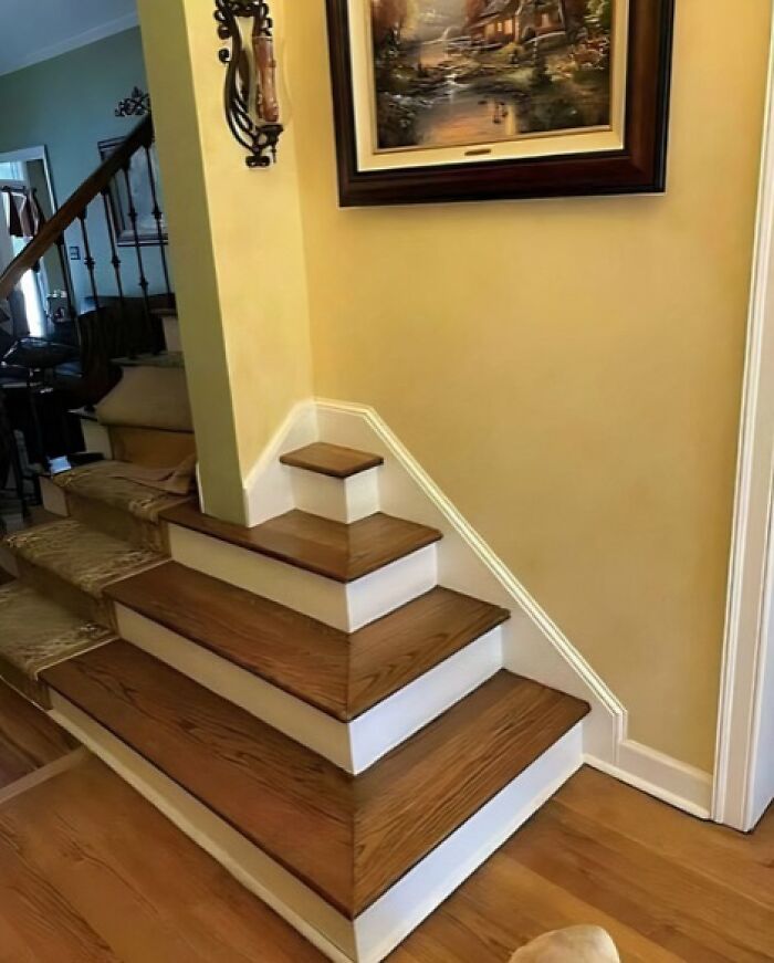 Stairs with a thick pillar obstructing the pathway, showcasing architecture and design fails.