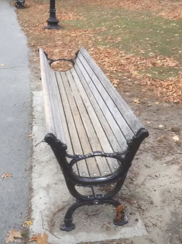 Comical architecture and design fails: a long park bench with an inverted U-shape in the middle, making it unusable.
