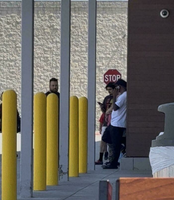 Men gathered near a stop sign, symbolizing stories of entitled men ignoring boundaries.