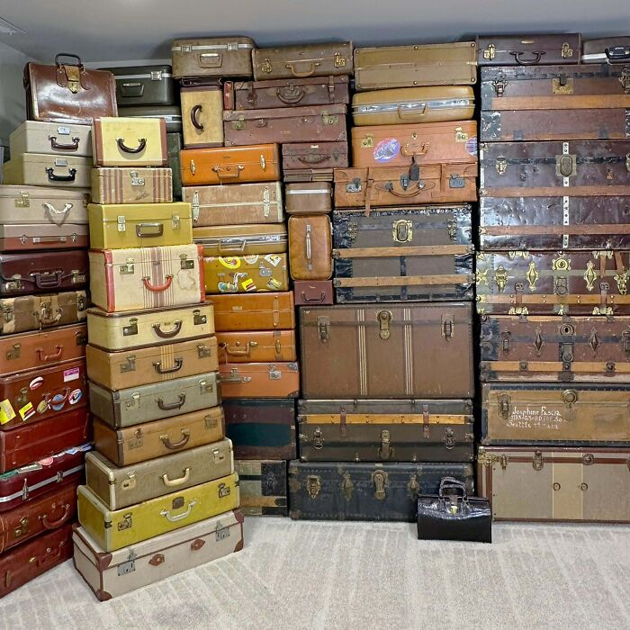 A room packed with a fascinating collection of vintage suitcases and trunks stacked high, displaying an unexpected hoard.