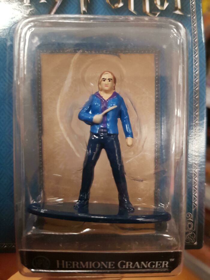 A poorly made Hermione Granger toy in a clear plastic package, showing a funny production fail.