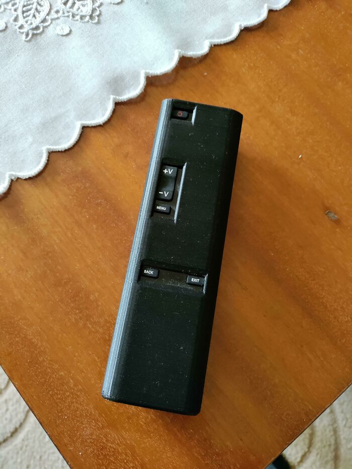 A close-up of a sleek black custom 3D printed remote control, designed to make everyday life much easier with its functional layout.