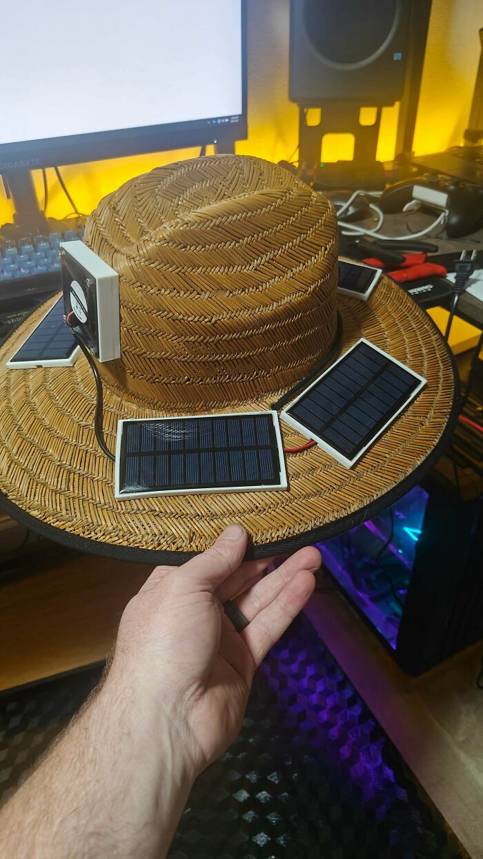 A straw hat with multiple solar panels and a fan, showcasing functional 3D prints for everyday life.