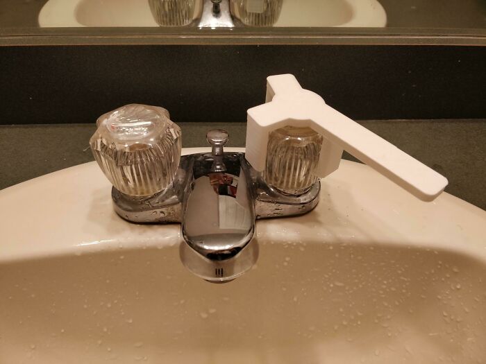 A white 3D printed handle attached to a faucet, illustrating functional 3D prints for everyday convenience.