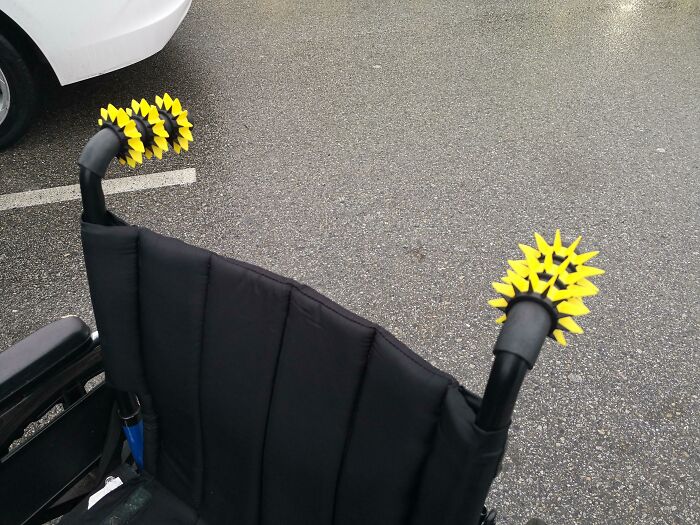 Yellow spiky functional 3D prints on wheelchair handles, making everyday life much easier.