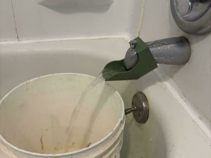 Water being diverted by a functional 3D printed spout extender into a bucket, simplifying everyday life tasks.