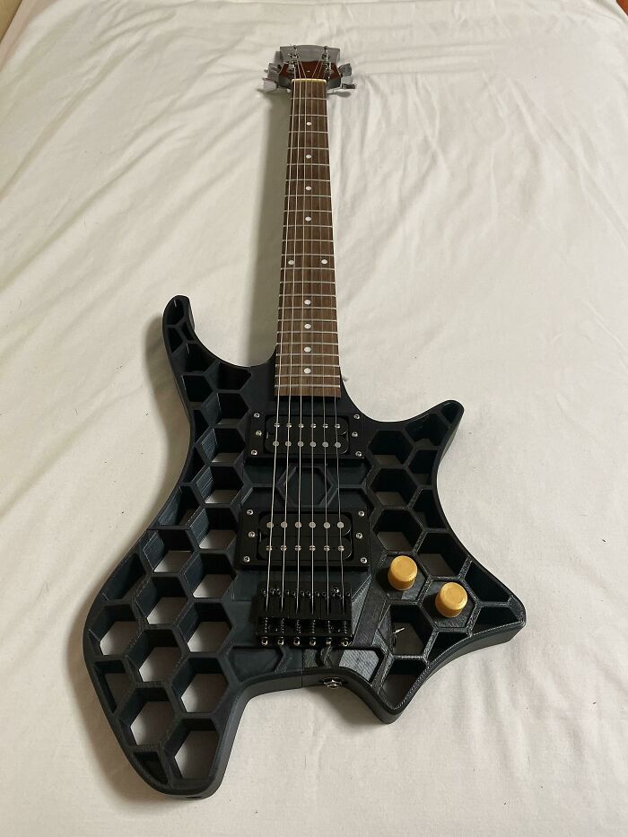 A black 3D print electric guitar with a hexagonal design, a functional 3D print making everyday life much easier.