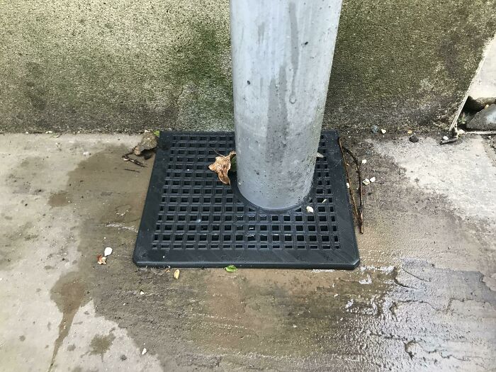 A black square 3D print acting as a base around a pole, showcasing a functional print for everyday life.