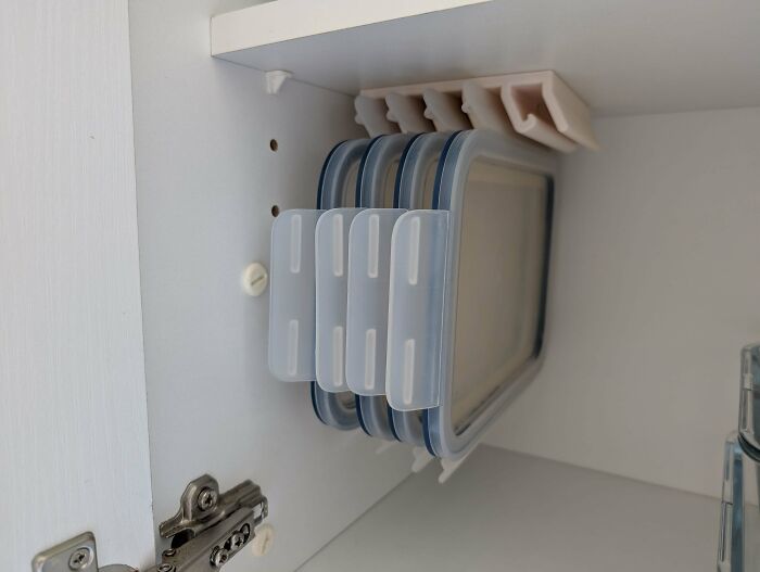 White cabinet interior showing a 3D print holding food containers, making everyday life much easier.