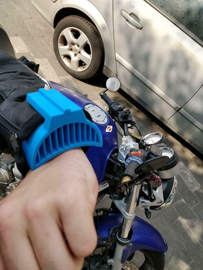 Blue 3D print attached to a biker's glove, making everyday life easier on a motorcycle.