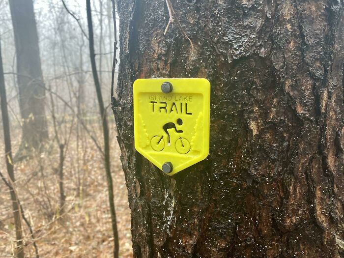 A yellow functional 3D print trail marker for Island Lake Trail, making everyday life easier for bikers.
