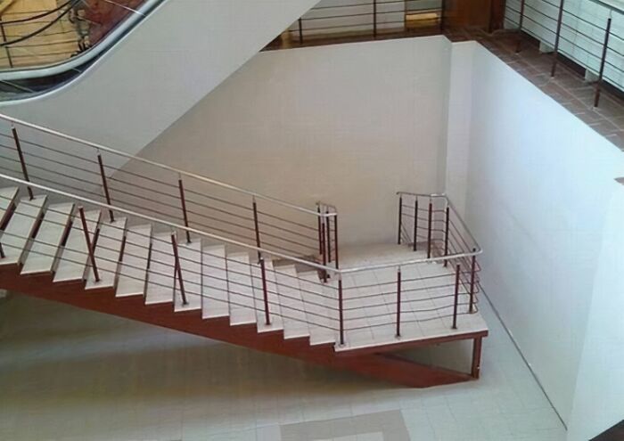 A modern staircase with a handrail that stops short, revealing a You Had One Job design flaw.