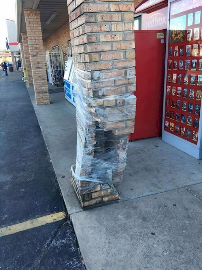 A brick pillar wrapped in plastic at a storefront, a clear instance of You Had One Job Fails.