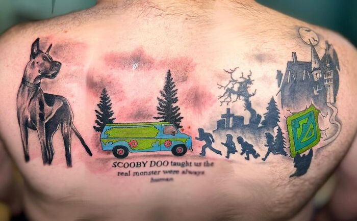 A full back tattoo of Scooby-Doo characters and the Mystery Machine, with a quote. A questionable tattoo idea from an artist.