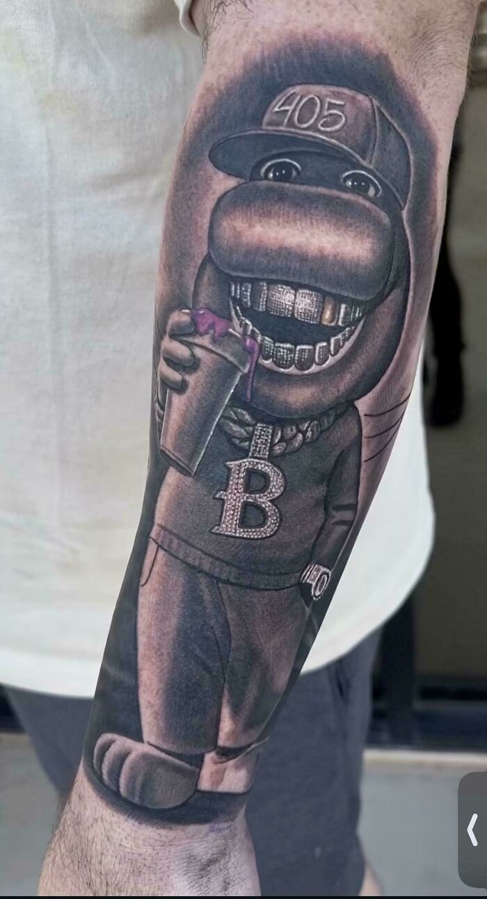 A tattoo of a cartoon hippo with a 405 hat, holding a drink, with gold teeth and a B pendant, showcasing a tattoo artist's talent.