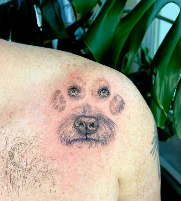 A tattoo artist's talent is wasted on a questionable tattoo idea of a dog's face as a paw print on a person's shoulder.