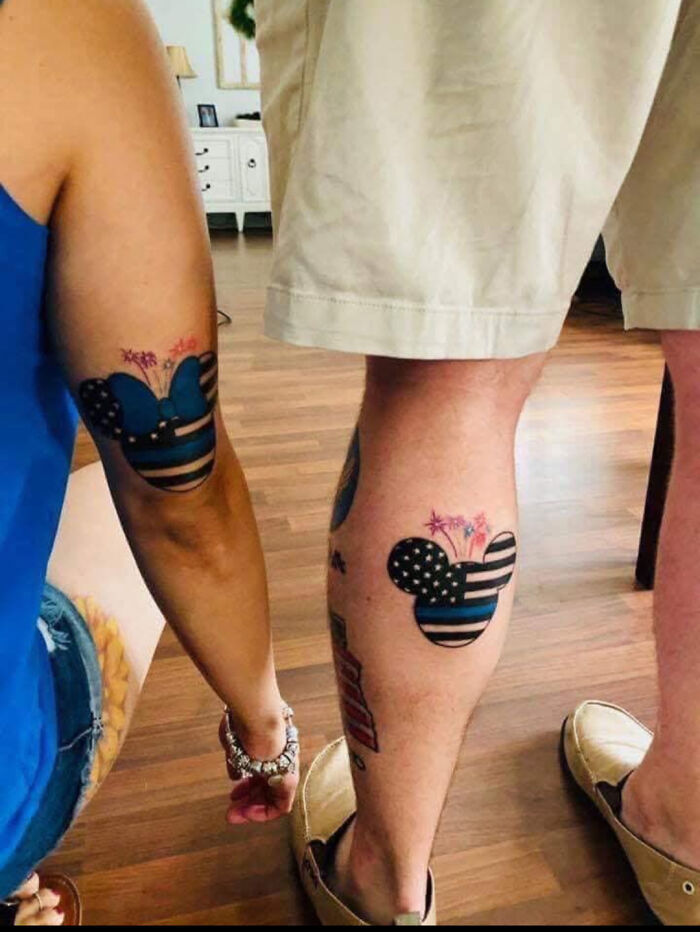 Matching arm and leg tattoos featuring Mickey and Minnie Mouse heads with a thin blue line flag pattern, showcasing the tattoo artist's talent.