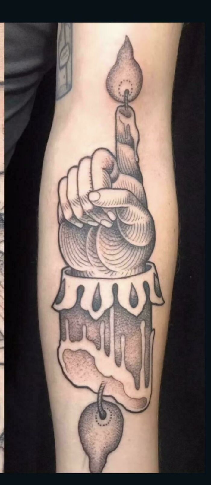 A tattoo artist's work on a forearm tattoo with questionable ideas featuring a hand holding a candle, designed with a unique, illustrative style.