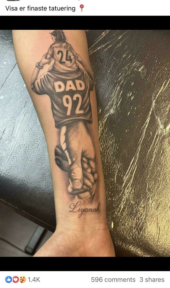A tattoo artist's talent is shown in a black and white tattoo of a child on a father's shoulders and holding hands.